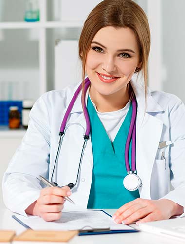 женщина врач сидит за столом с ручкой в руке